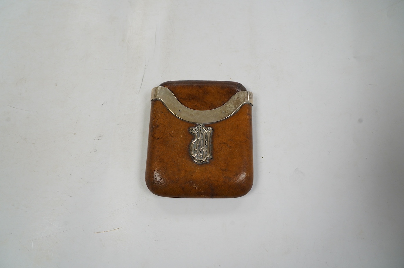 An Edwardian silver mounted leather cigar case with crest and motto 'Candidior Nive' (whiter than snow), Alfred Clark, London, 1906, retailed by Clark of New Bond Street, 12.3cm. Condition - poor to fair
